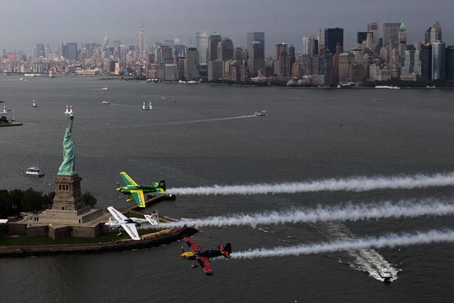 Michael Goulian of USA, Matthias Dolderer of Germany and Kirby Chambliss of USA fly past the Manhattan Skyline and the Statue of Liberty during the Red Bull Air Race New York Calibration Day.